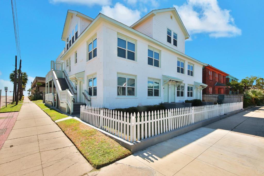a white house with a white picket fence at Oceanview by the Galvez in Galveston
