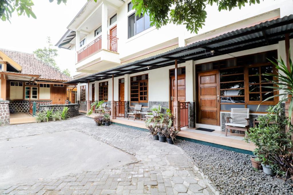 a building with chairs and tables in a courtyard at Hotel Wismancala Kaliurang in Kaliurang