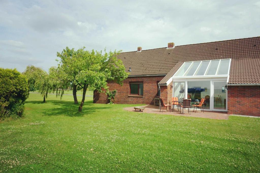 una casa de ladrillo con una mesa y sillas en un patio en Ferienhaus Waldblick, 35209, en Hesel