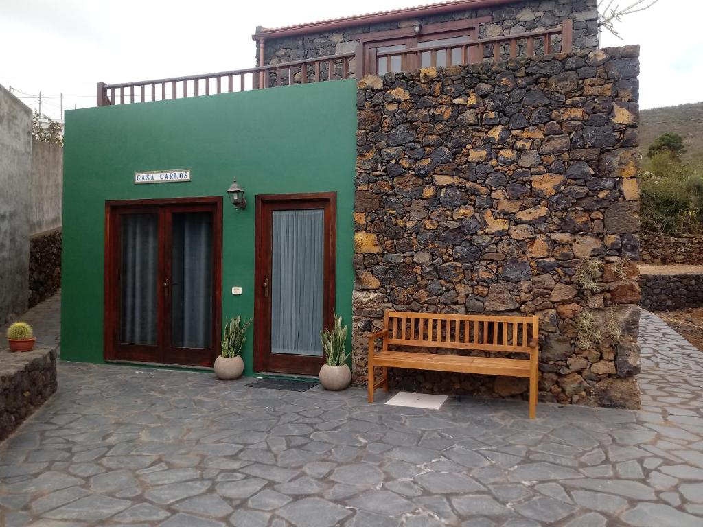 Isora的住宿－Casa Rural Casa Carlos，石墙建筑前的长凳