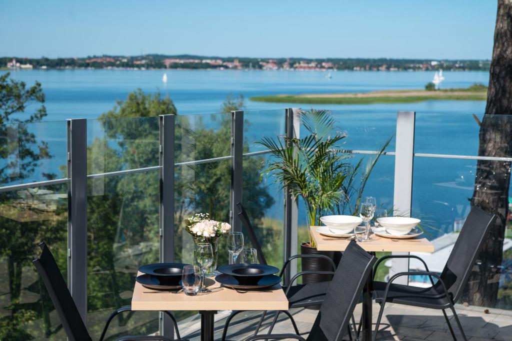 a table and chairs with a view of the water at Resort Niegocin in Wilkasy