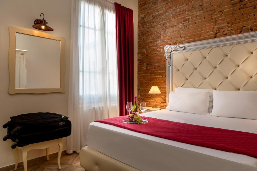 a bedroom with a bed and a window with a suitcase at Residenza Conte di Cavour & Rooftop in Florence