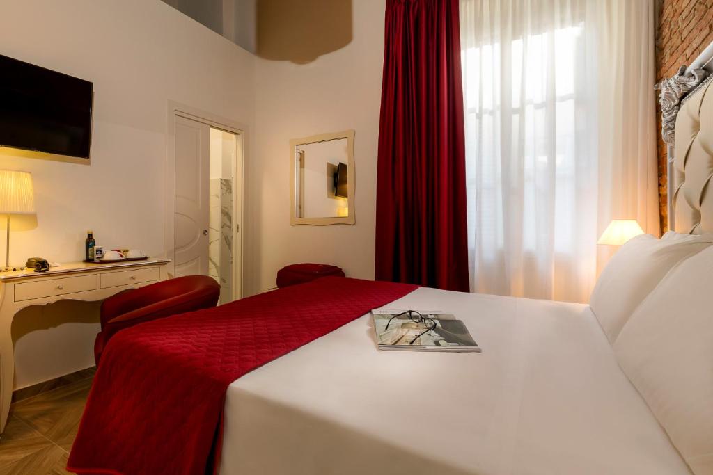 a hotel room with a bed with a red blanket at Residenza Conte di Cavour & Rooftop in Florence