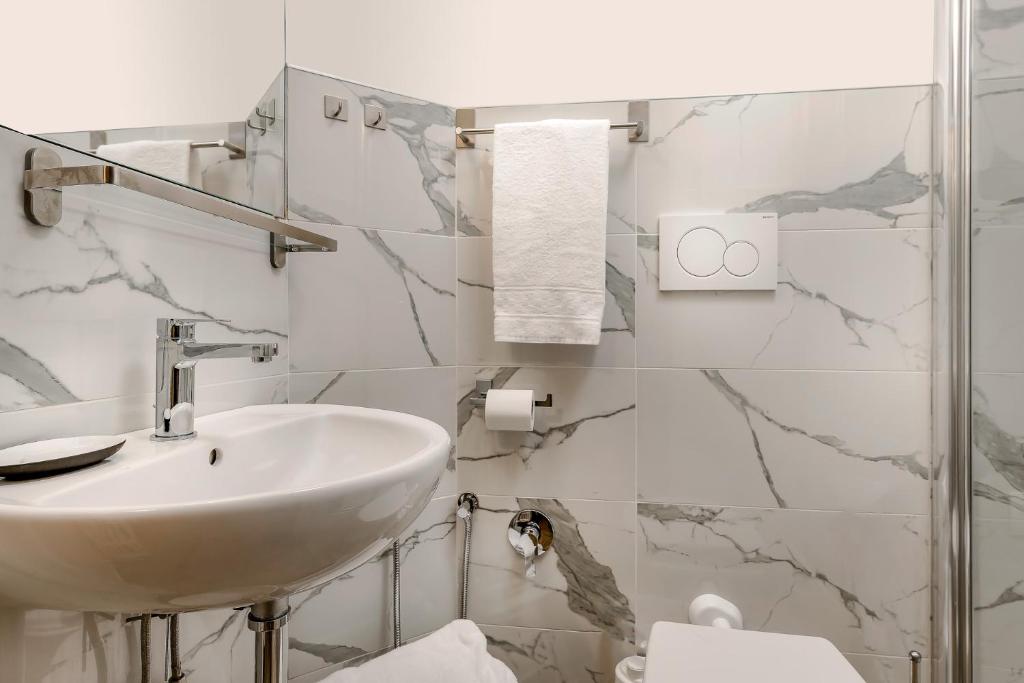 a white bathroom with a sink and a toilet at Residenza Conte di Cavour & Rooftop in Florence