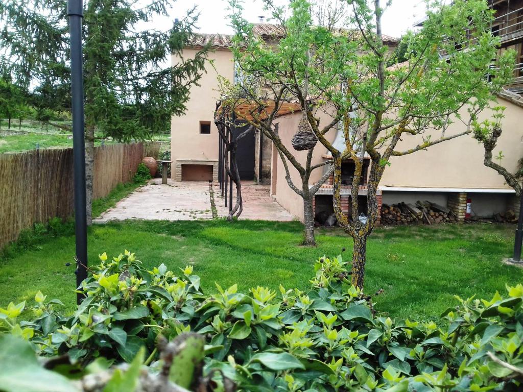une cour avec une maison et un arbre dans l'établissement Casa Julián Fábrica Giner, à Morella