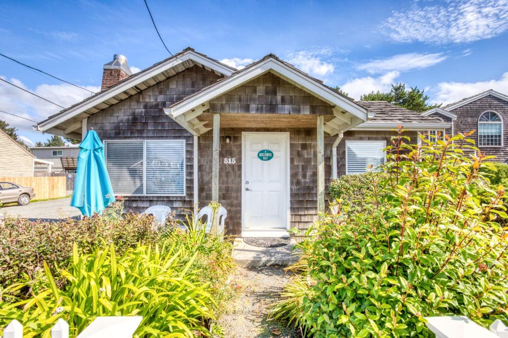 a house with a white door and some bushes at Beaches Inn | Buccaneer Bay Bungalow in Cannon Beach