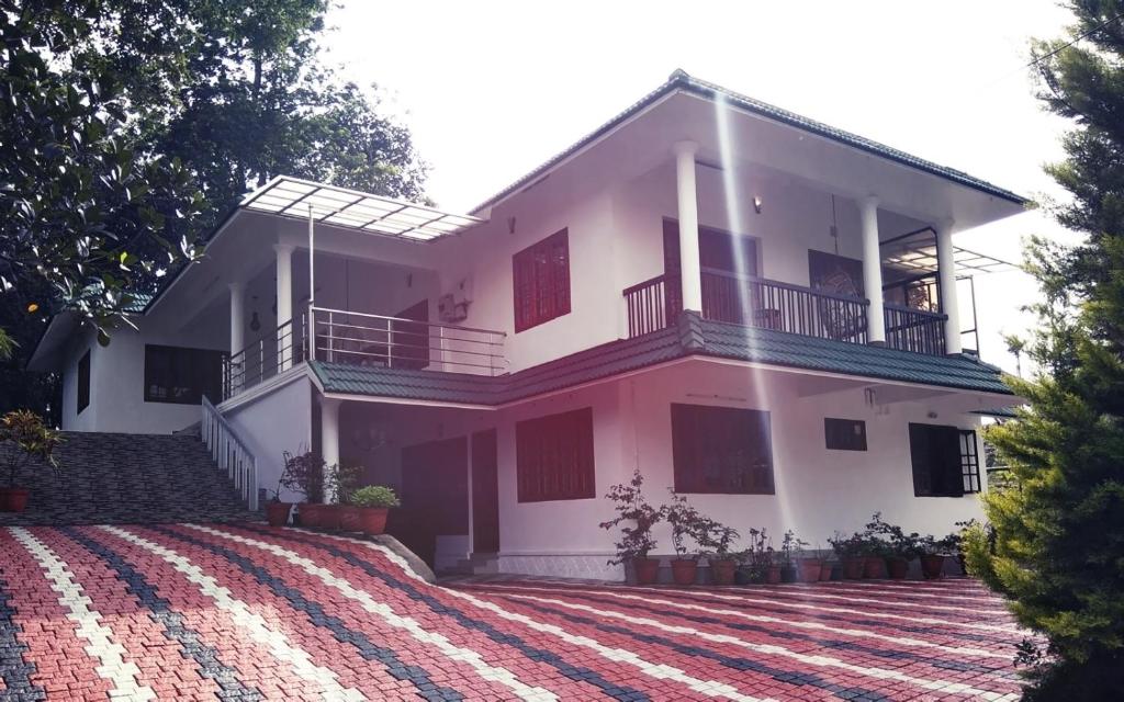 duży biały dom z dużym dziedzińcem w obiekcie Hill Mist Thekkady w mieście Thekkady