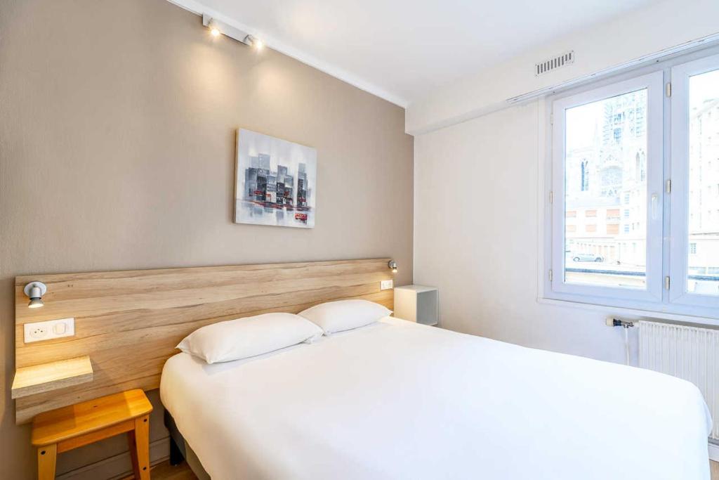 una camera da letto con un grande letto bianco e una finestra di Comfort Hotel Rouen Alba a Rouen