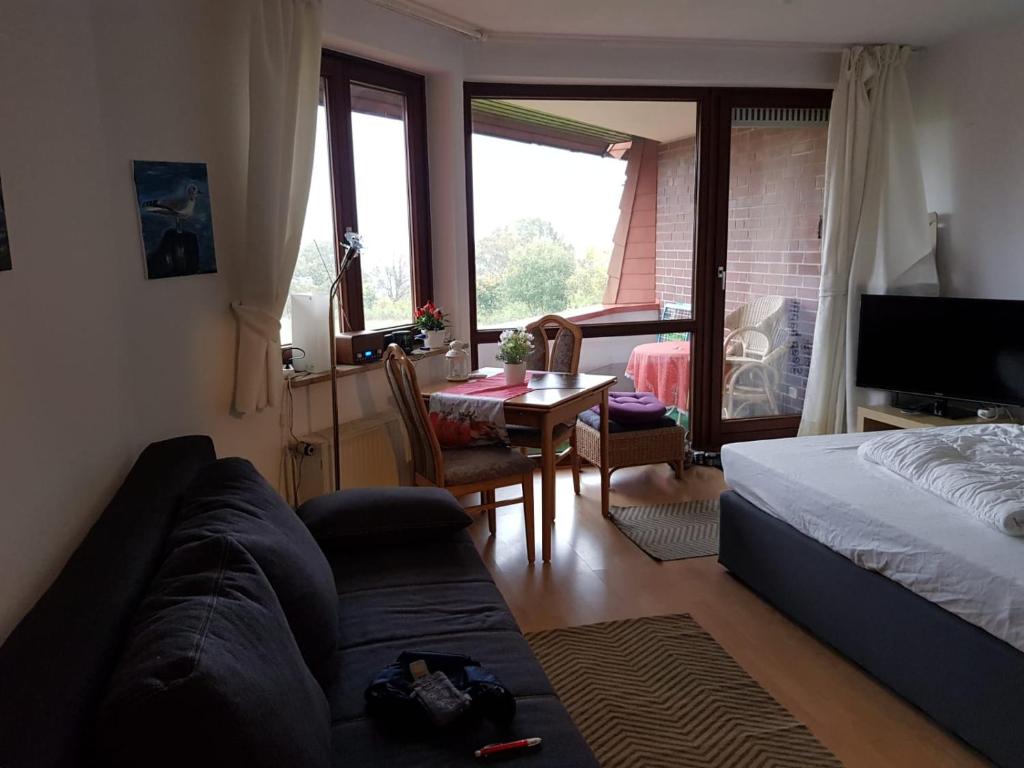 a living room with a couch and a bed and a table at Apartment am Hafen in Travemünde
