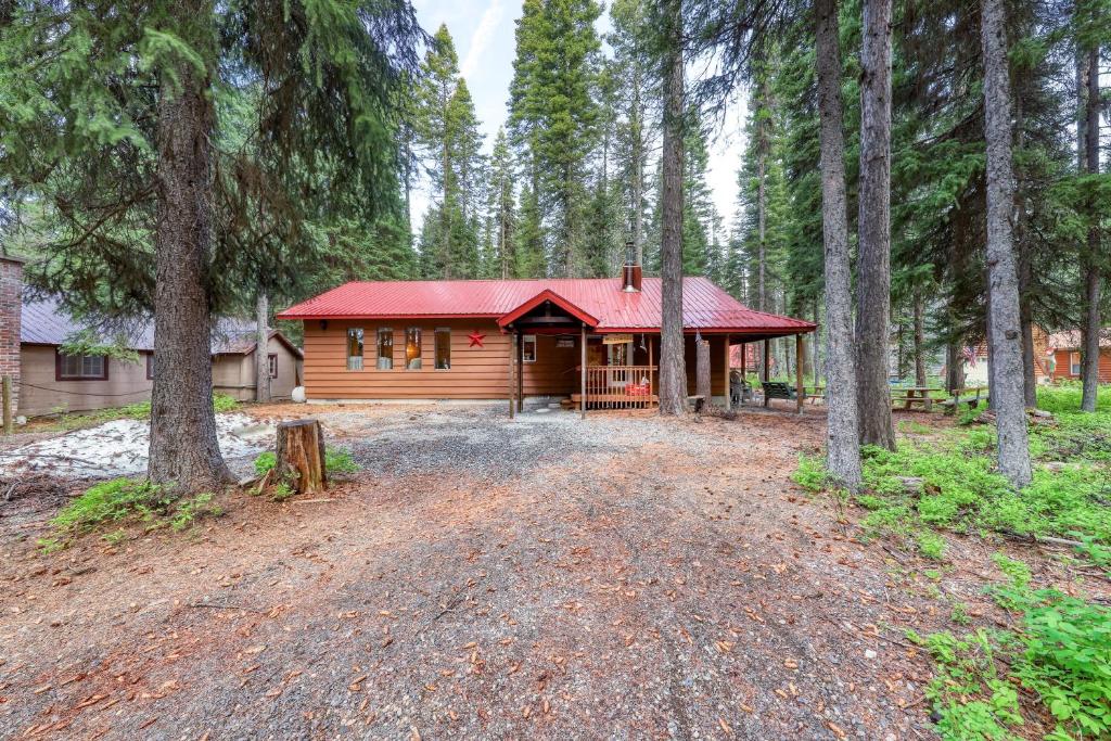 マッコールにあるAwesome Payette Lake Cabinの森の赤い屋根の丸太小屋
