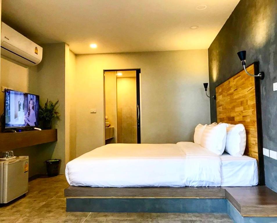a hotel room with a bed and a television at Banyan Resort @Rayong in Ban Phe