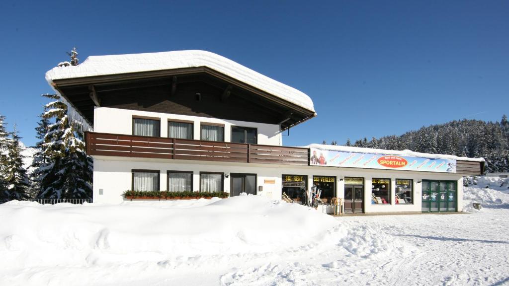 a building with snow on the ground in front of it at Sportalm Apartments in Leutasch