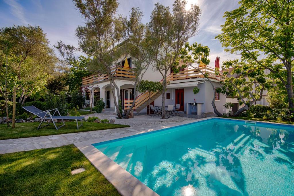 een huis met een zwembad in de tuin bij Villa Neroli in Krk