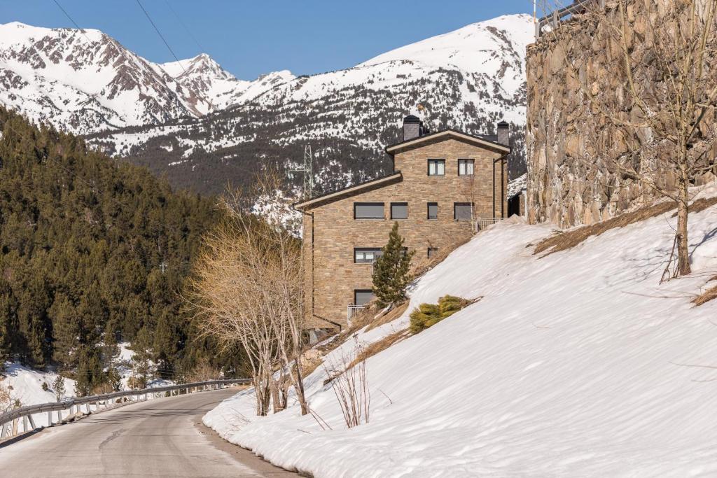 a house on a snow covered hill with a mountain at Pierre & Vacances Andorra Sunari Peretol in Bordes d´Envalira