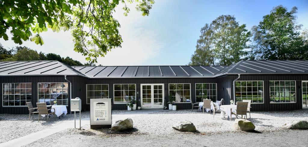 a black building with a table and chairs in front of it at Danhostel Kerteminde in Kerteminde