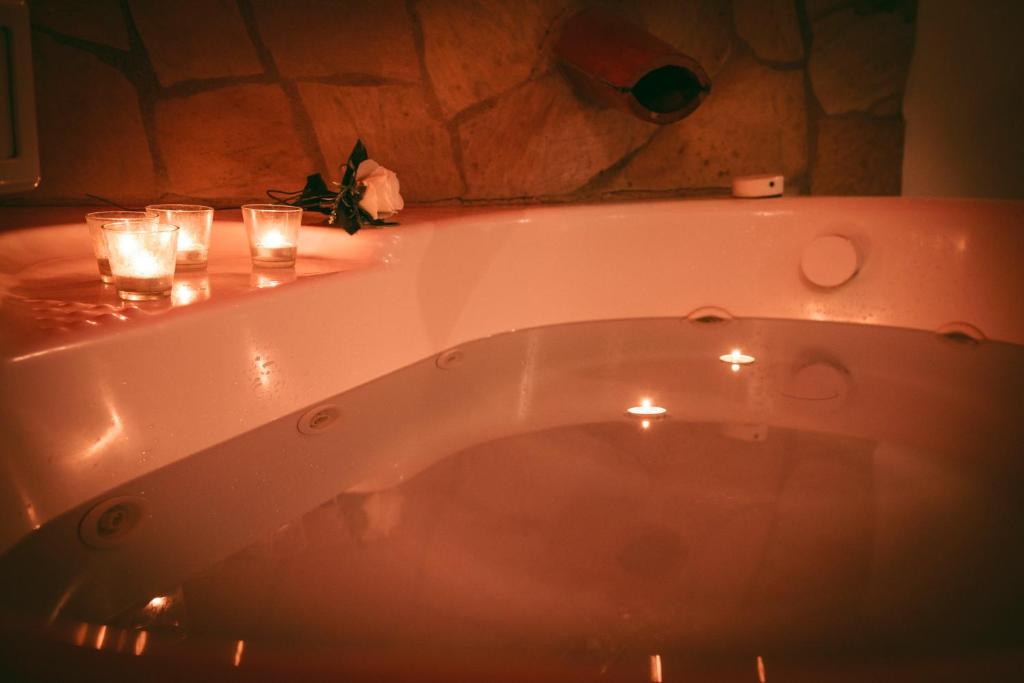 El baño incluye bañera con velas y vasos. en Agriturismo Tenuta Monte La Guardia, en Castel Giuliano