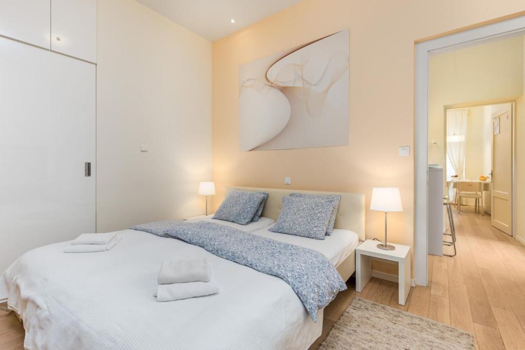 een slaapkamer met 2 bedden en een schilderij aan de muur bij Apartment Rona Opatija Superior in Opatija