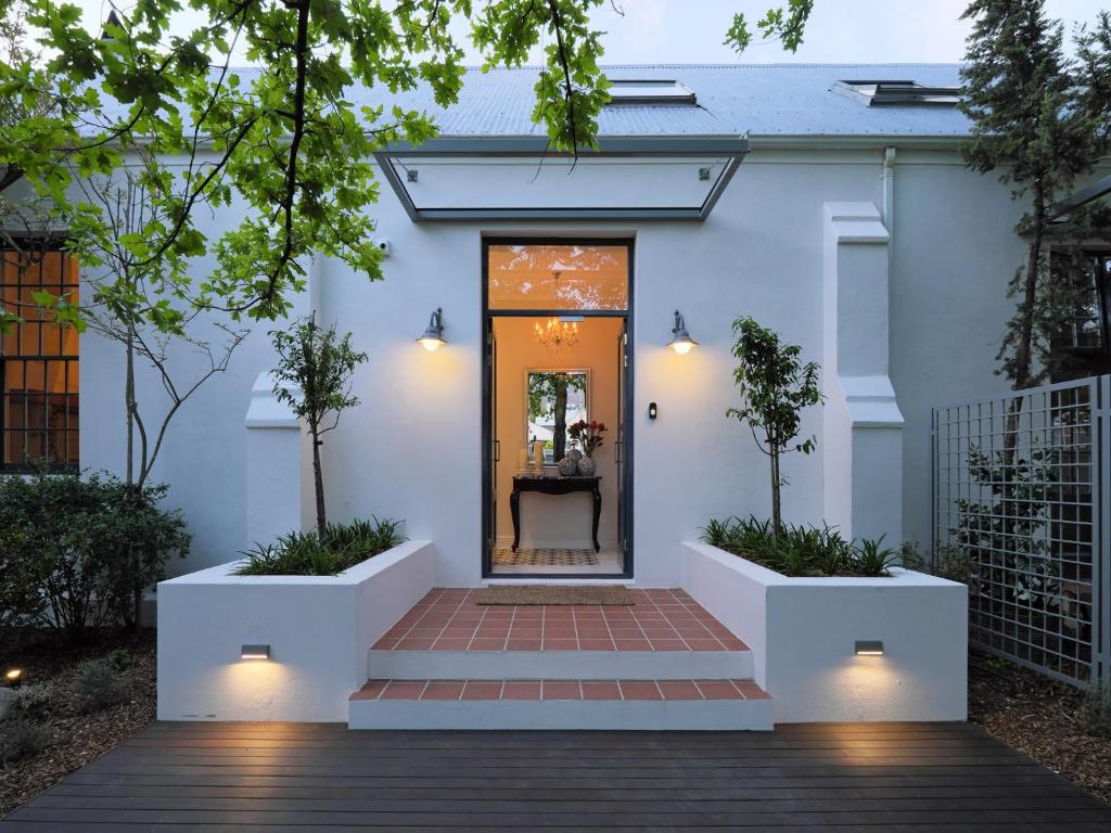 a white house with a pathway leading to the front door at Chapter House Boutique Hotel by The Living Journey Collection in Franschhoek
