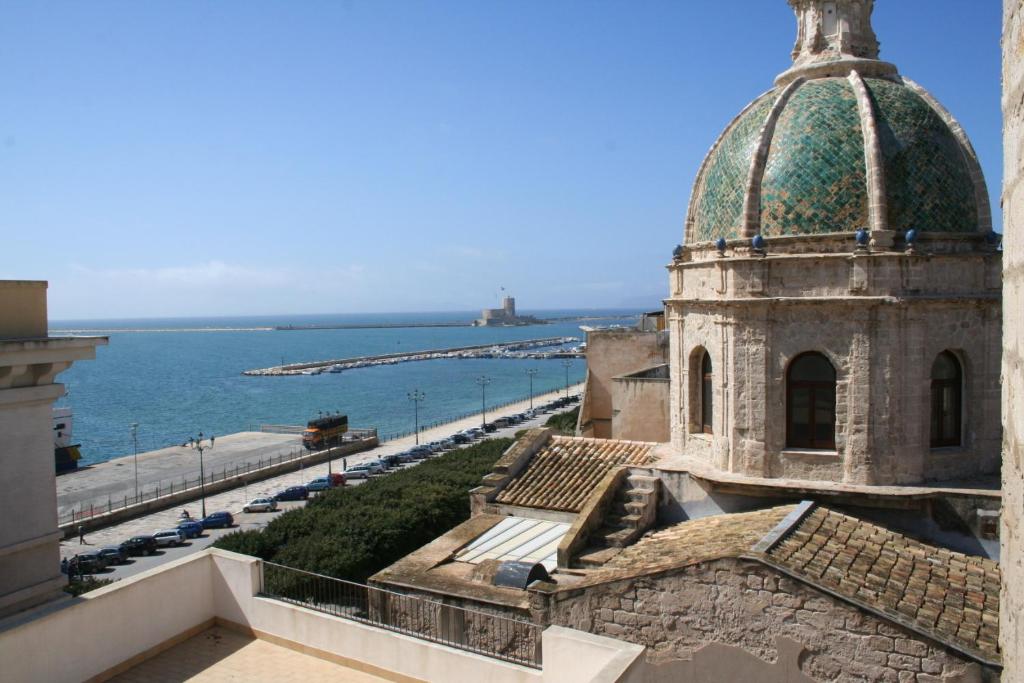 un edificio con tetto a cupola verde e l'oceano di Appartamento Giglio a Trapani