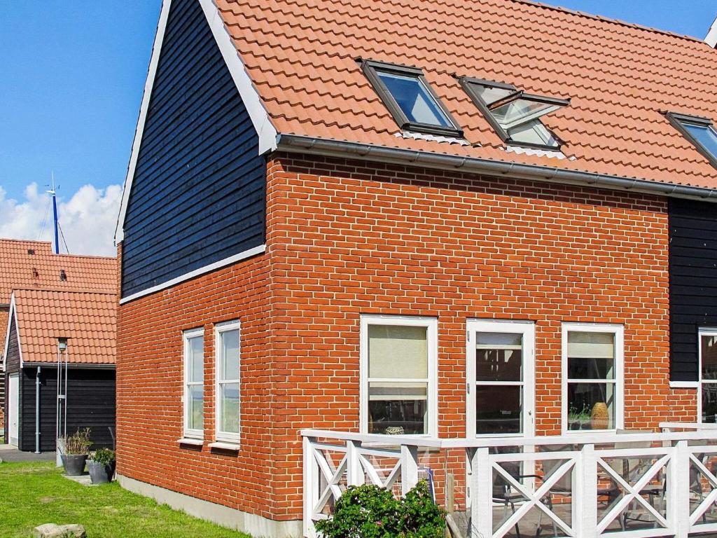 ein rotes Backsteinhaus mit schwarzem Dach in der Unterkunft 4 person holiday home in Borre in Borre