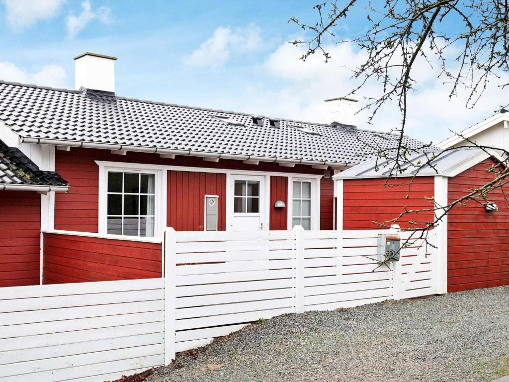 una casa rossa e bianca con una recinzione bianca di 6 person holiday home in Aabenraa a Aabenraa