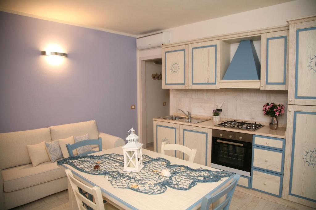 uma cozinha e sala de jantar com uma mesa e um sofá em La Rosa Del Mare em Castelsardo