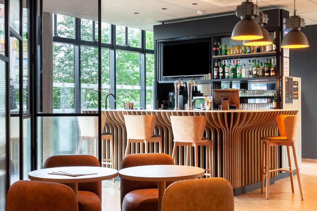 a restaurant with tables and chairs and a bar at B&B HOTEL Paris Porte des Lilas in Paris