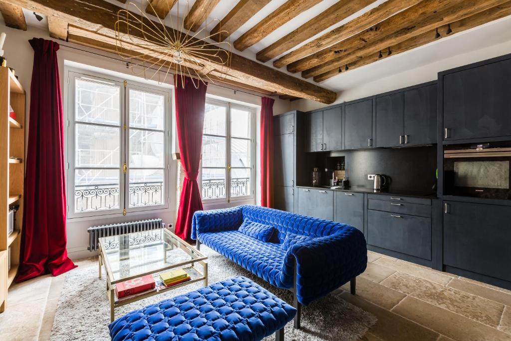 un salon avec un canapé bleu et une table dans l'établissement Veeve - Saint-Louis Style, à Paris
