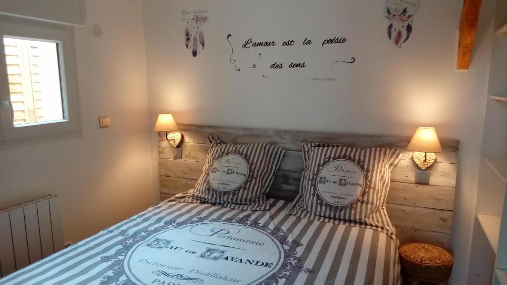 een slaapkamer met een bed met 2 kussens en een schrijftafel bij CHALET DU LAC DISNEYLAND PARIS- TGV-ReR in Montévrain