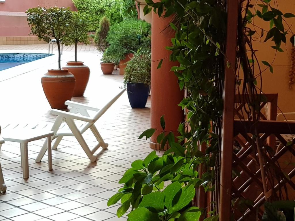 een patio met een witte stoel en potplanten bij Dúplex Nigrán in Nigrán