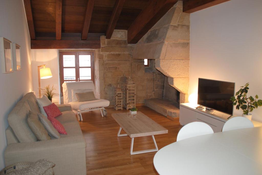 ein Wohnzimmer mit einem Sofa und einem Kamin in der Unterkunft Piso en antiguo palacete del casco histórico in Pontevedra