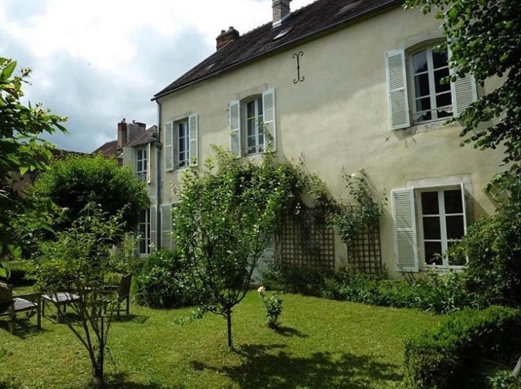 ein Haus mit einem Garten mit einem Baum davor in der Unterkunft La Villa Ribière in Auxerre