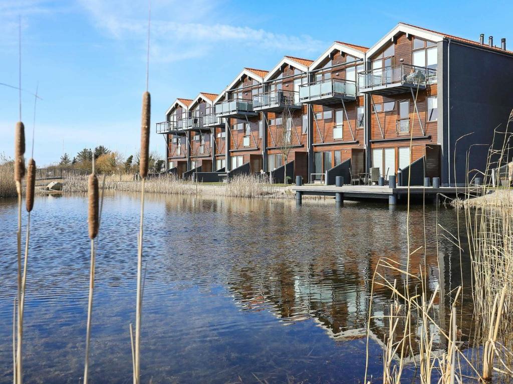 a row of apartment buildings next to a body of water at 4 person holiday home in Bogense in Bogense