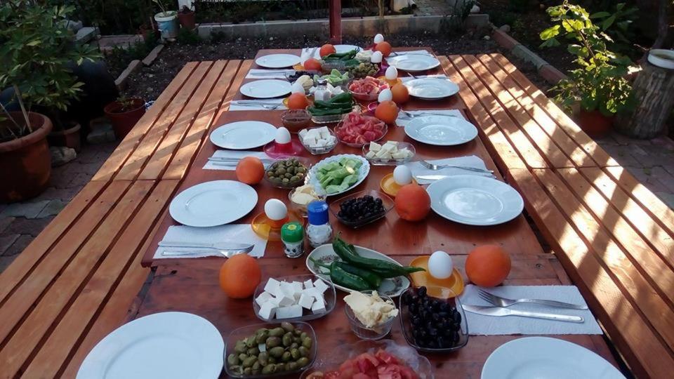 a long wooden table with plates of food on it at Keramos Pansiyon in Finike