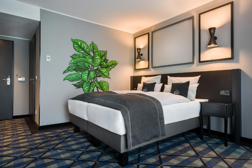 ein Schlafzimmer mit einem Bett mit einer Pflanze darauf in der Unterkunft the niu Square in Mannheim