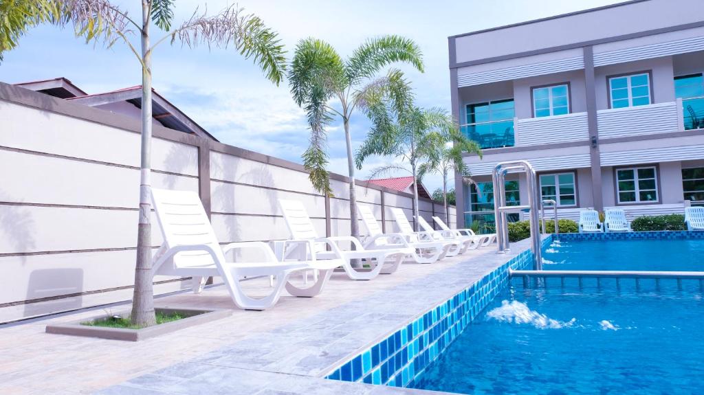 a pool with lounge chairs next to a building at Aneeda Inn in Pantai Cenang