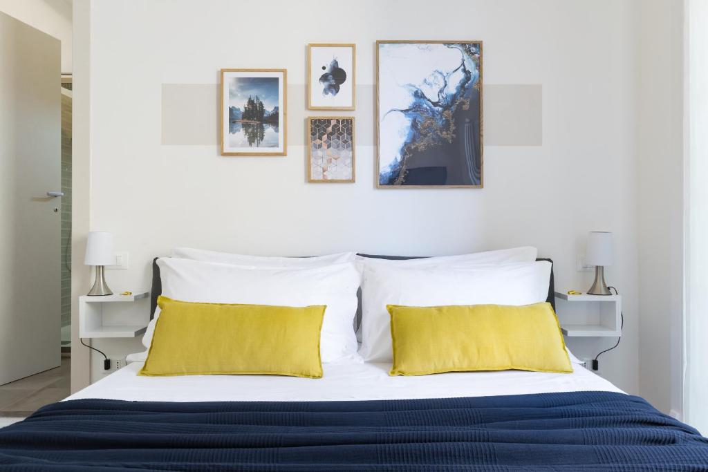 a bedroom with a large bed with yellow pillows at Biasanòt Mini in Bologna