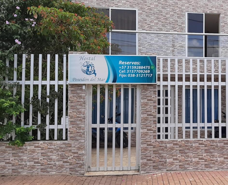 una puerta con una señal frente a un edificio de ladrillo en Hostal Poseidon del Mar, en San Andrés