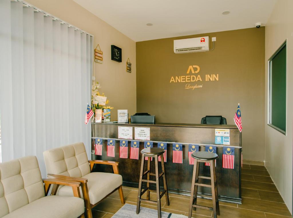 a lobby with a bar with two stools at Aneeda Inn in Pantai Cenang
