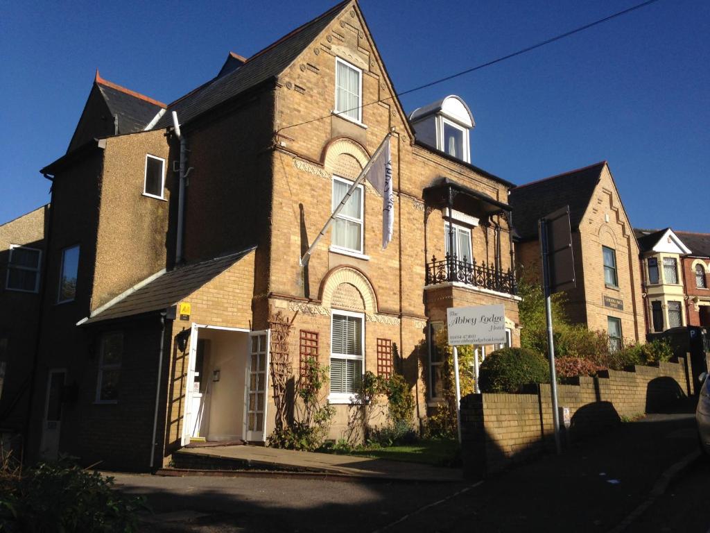 uma grande casa de tijolos com uma placa em frente em Abbey Lodge Hotel em High Wycombe