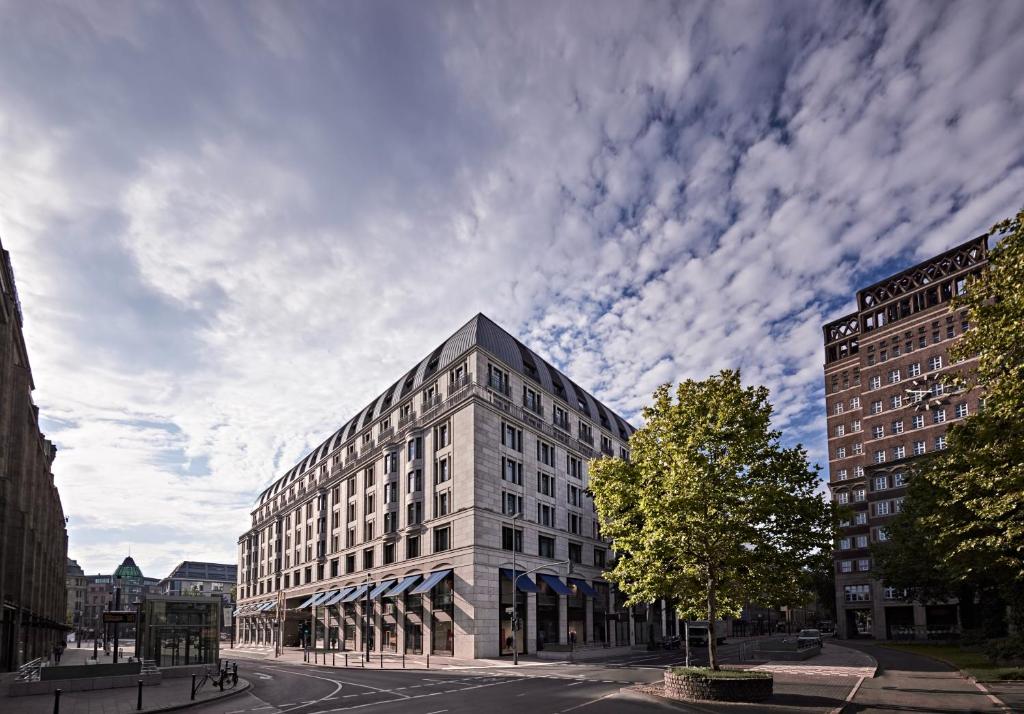 un edificio en una calle de la ciudad con un cielo nublado en Breidenbacher Hof, Best Grandhotel 2024 - Die 101 Besten en Düsseldorf