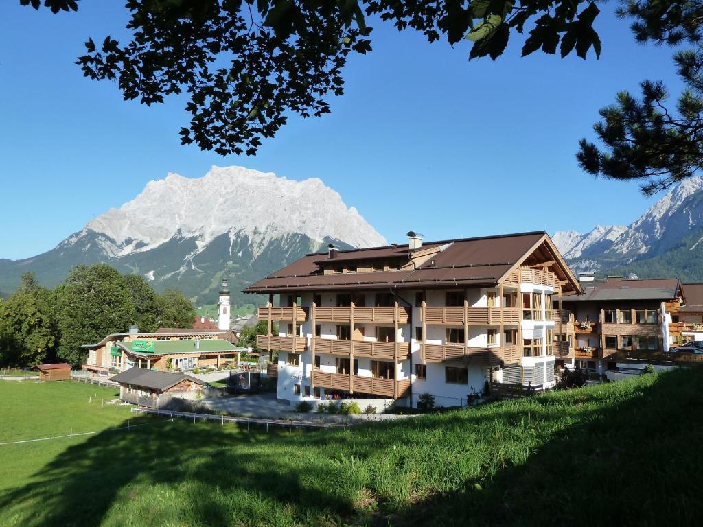 a large building with a mountain in the background at Apart Ideal in Lermoos