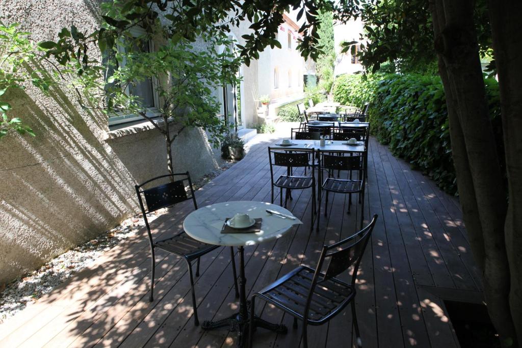 a row of tables and chairs on a patio at Hôtel Ulysse Montpellier Centre in Montpellier