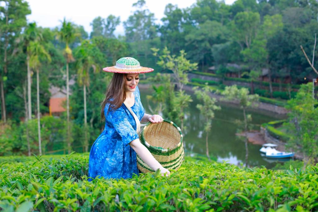 a woman in a blue dress and hat holding a basket at Saj Vagamon Hideout in Vagamon