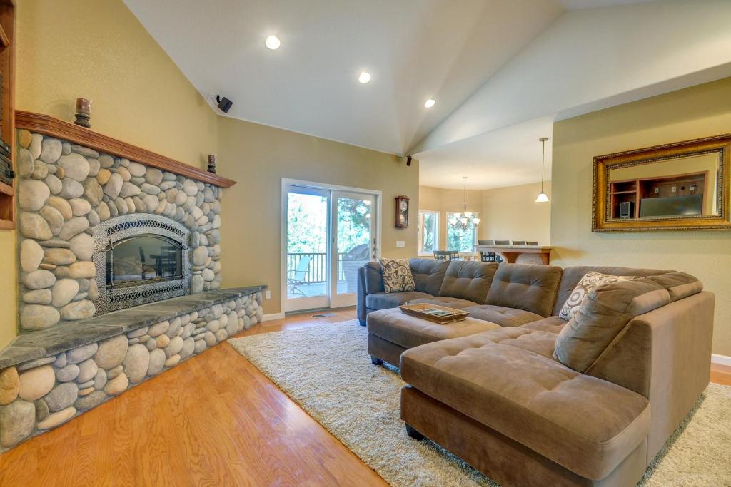 a living room with a couch and a stone fireplace at Mule Deer Cabin (4-538) in Groveland