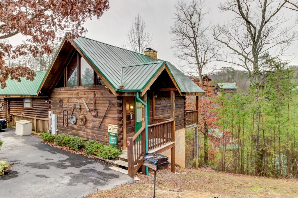 Cabaña de madera con techo verde en Wildwood, en Pigeon Forge