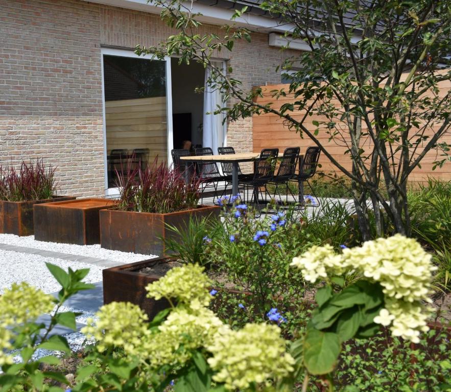 een tuin met een tafel, stoelen en bloemen bij Vakantiewoning Lescaut in Hamme