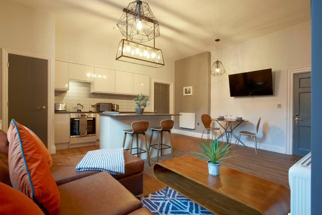 a living room and kitchen with a couch and a table at The Matcham at Claremont Apartments in Leeds