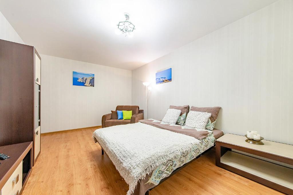 明斯克的住宿－Helen Apartments (Olimp)，一间卧室配有一张床和一把椅子
