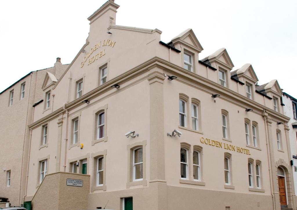 um grande edifício branco com um cartaz em The Golden Lion Hotel em Maryport